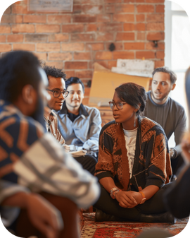 A Black woman talks to a diverse group of community members.